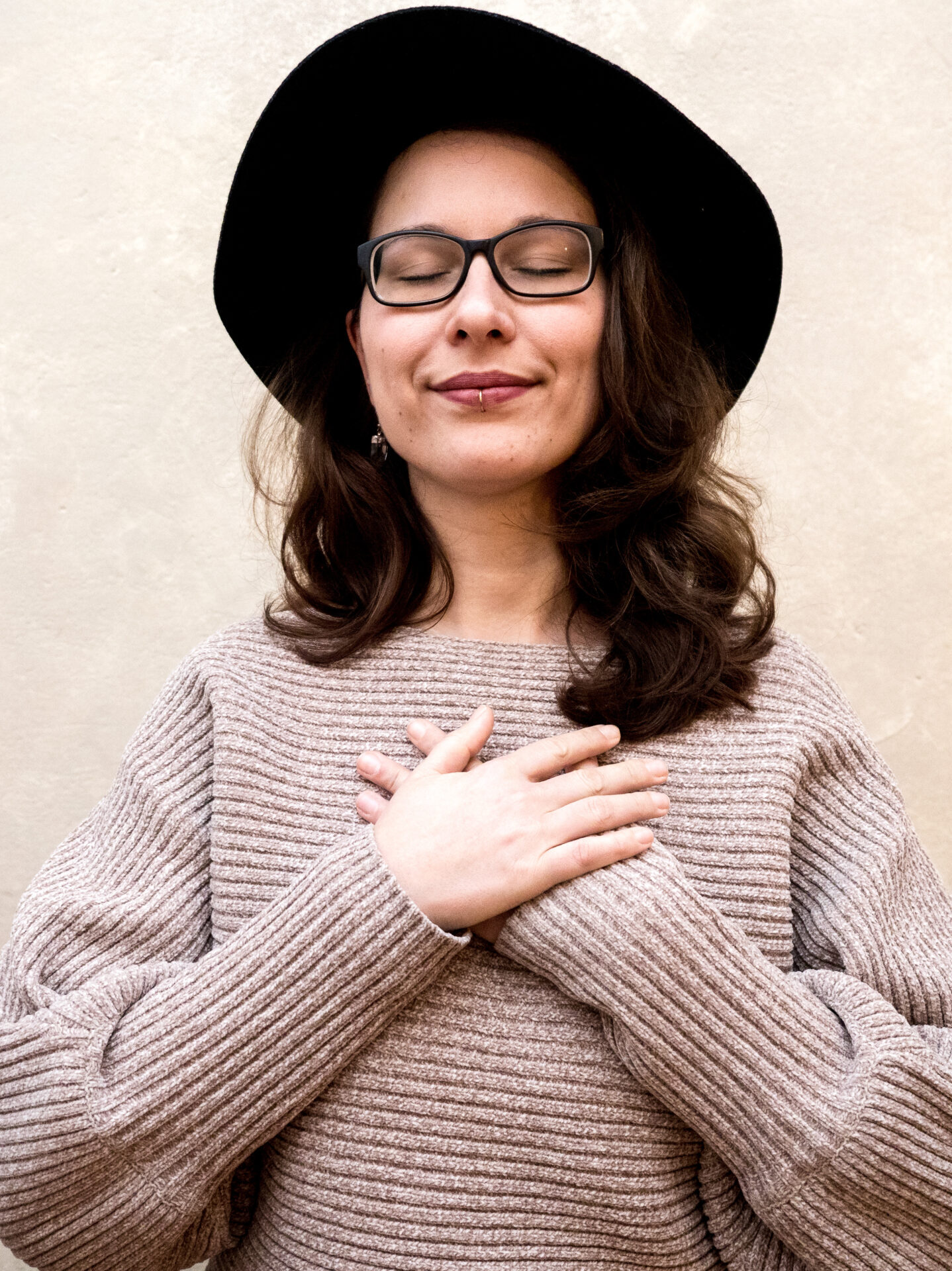 Julia Gohlke, Heilpraktikerin für Psychotherapie in Berlin, steht mit geschlossenen Augen und den Händen auf dem Herzen – Symbolbild für Transformation, Heilung und innere Veränderung.